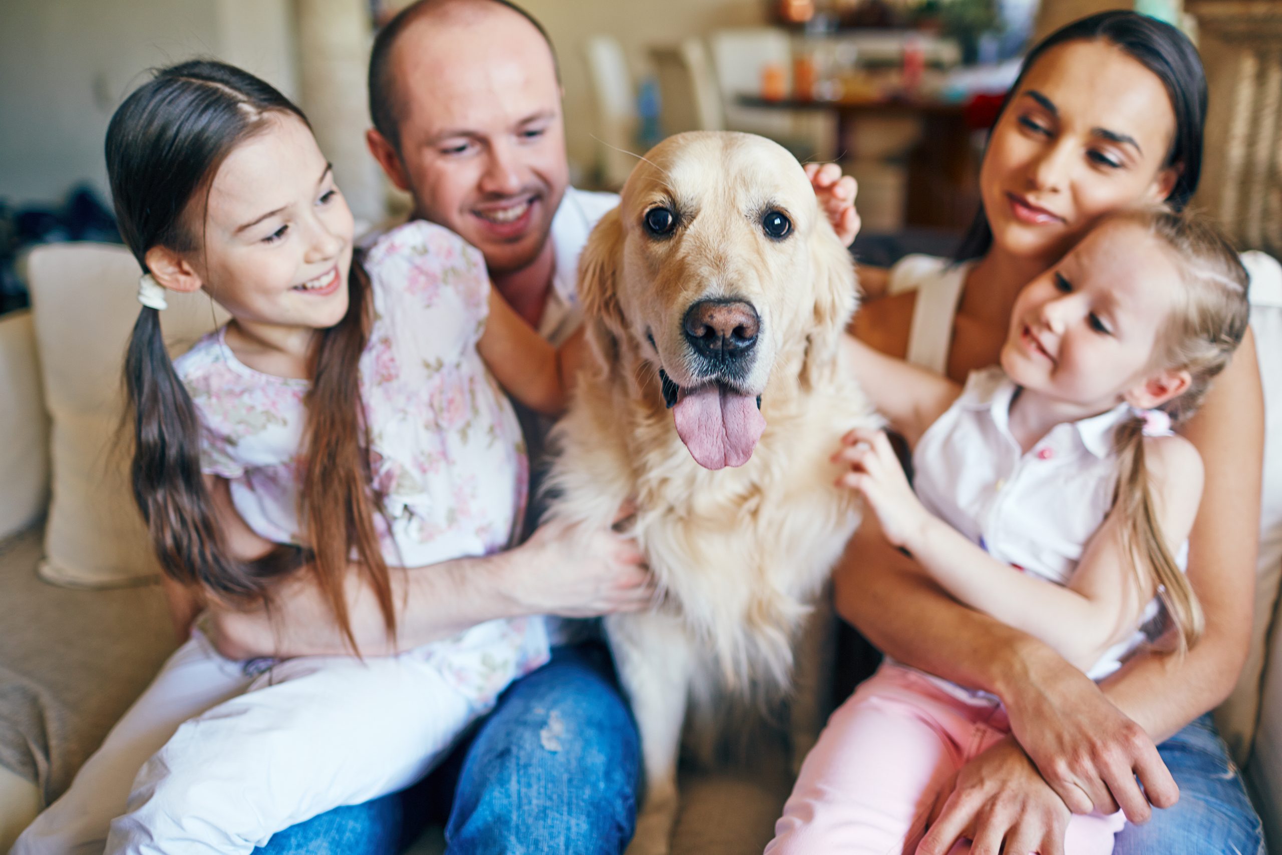 family sitting with pet dog